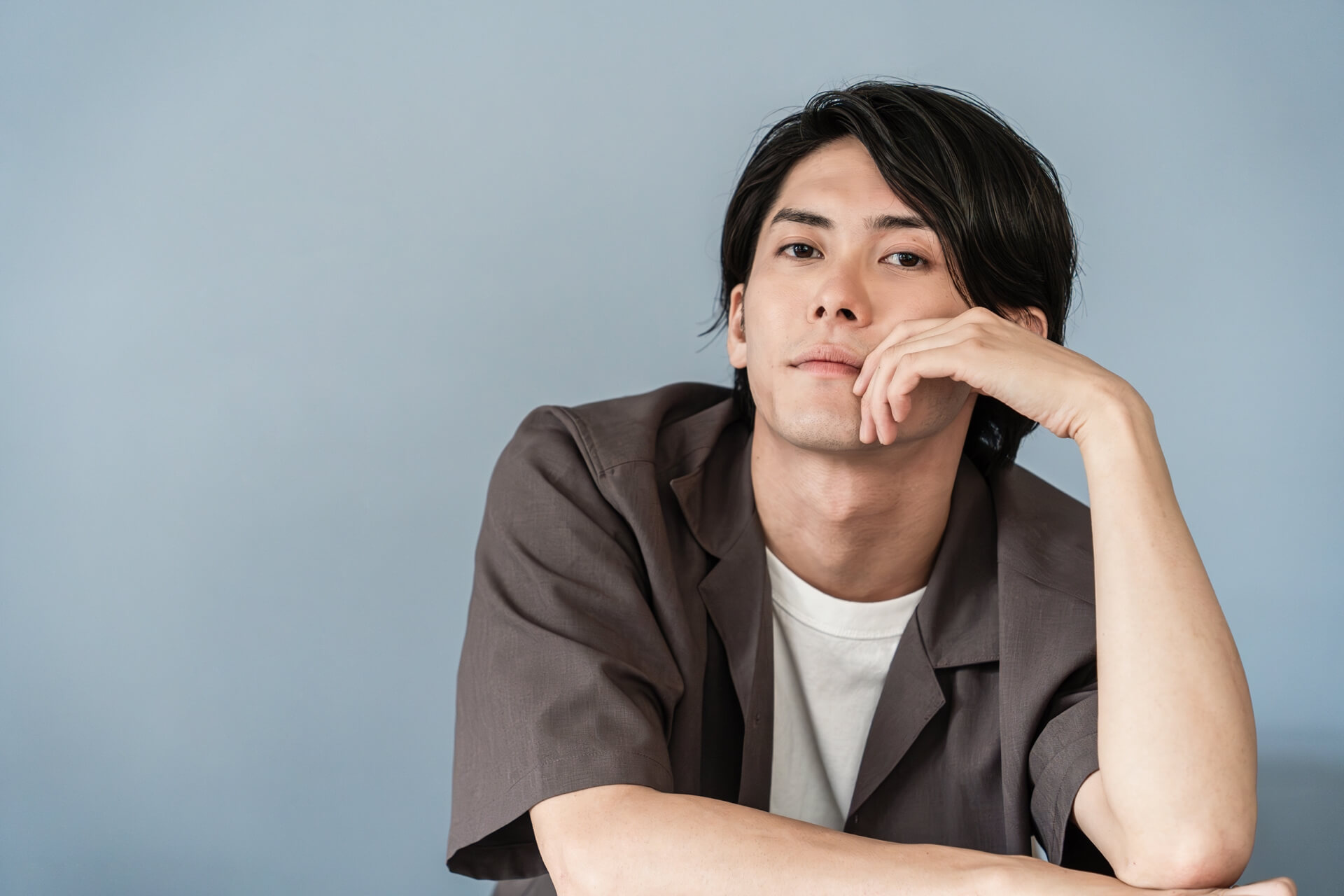 グレーのシャツを着た思案する男性